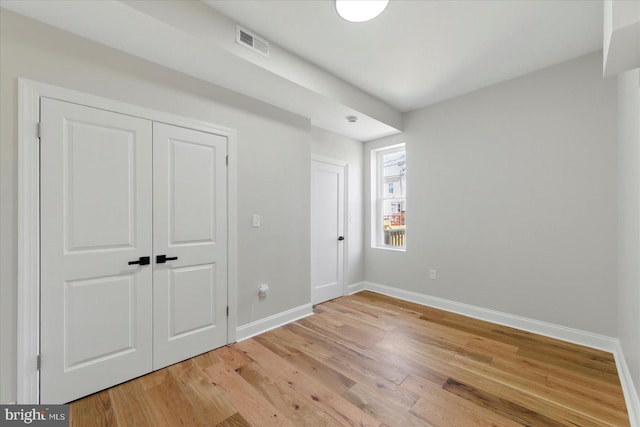 2424 W Lanvale St, Baltimore, MD 21216 - unfurnished bedroom featuring baseboards, light wood finished floors, and a closet