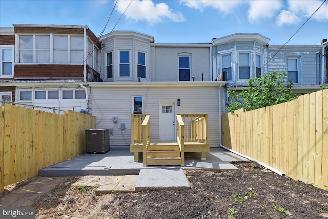 2424 W Lanvale St, Baltimore, MD 21216 - back of property featuring central AC unit, a fenced backyard, a wooden deck, and a patio