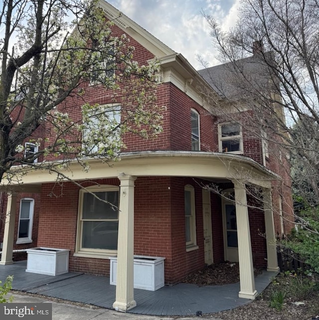 view of home's exterior with covered porch and brick siding
