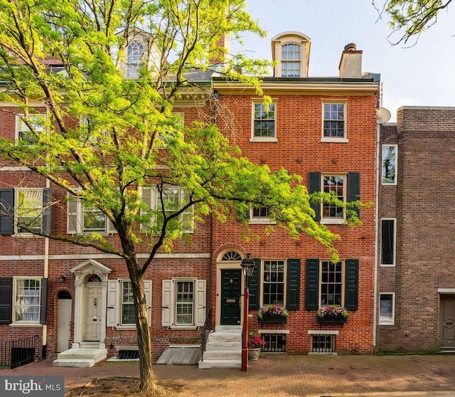 exterior space featuring brick siding, a chimney, and entry steps