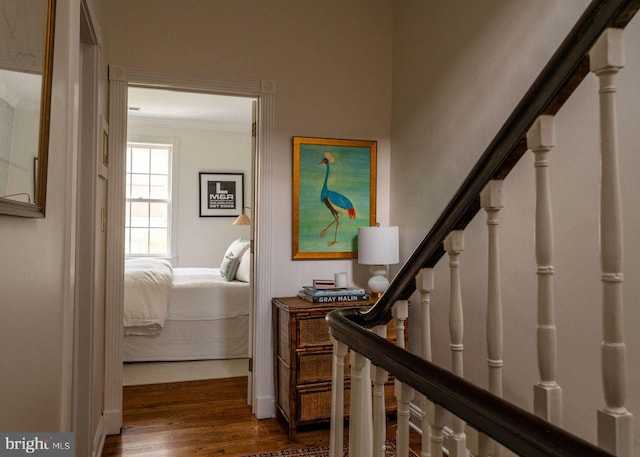 hallway with crown molding, dark wood-style floors, and stairs