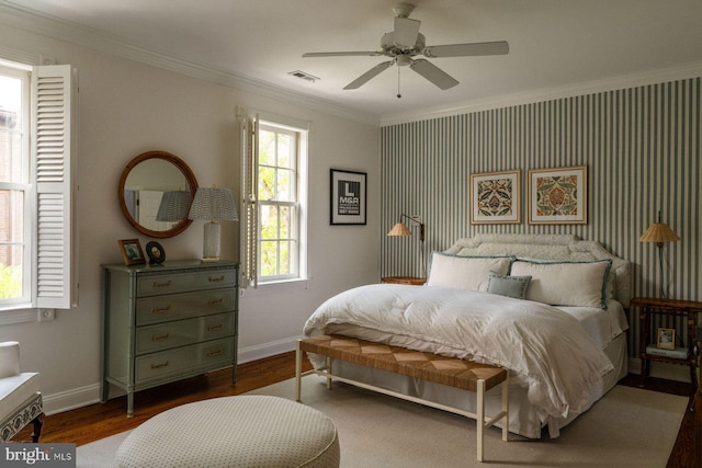 bedroom with crown molding, multiple windows, baseboards, and wood finished floors
