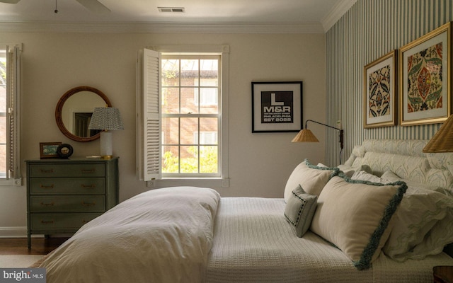 bedroom with crown molding, multiple windows, baseboards, and wood finished floors