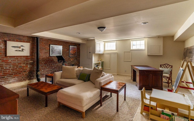 living area featuring light colored carpet, baseboards, and brick wall