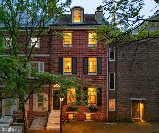 rear view of property with brick siding and a chimney