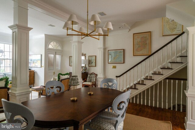 dining area featuring ornate columns, wood finished floors, stairs, and ornamental molding