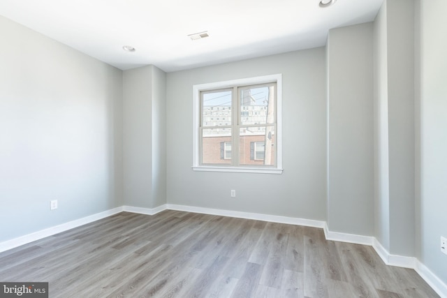 spare room with baseboards, recessed lighting, light wood-style flooring, and visible vents
