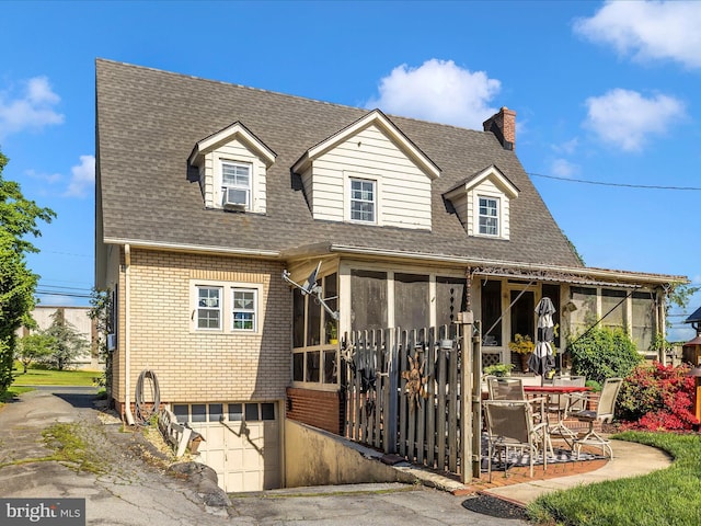 1606 N Market St, Frederick, MD 21701 - view of front of property featuring a sunroom, roof with shingles, brick siding, an attached garage, and asphalt driveway