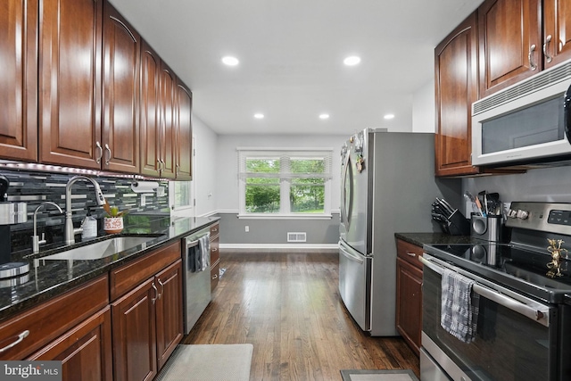 6404 Yates Ford Rd, Manassas, VA 20111 - kitchen featuring stainless steel appliances, a sink, dark wood-style floors, dark stone counters, and baseboards