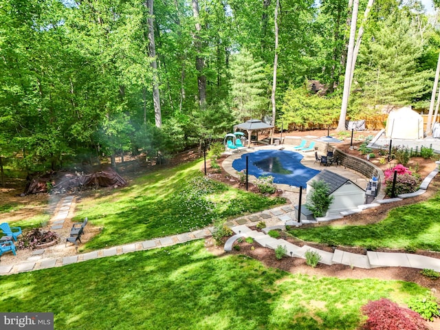 6404 Yates Ford Rd, Manassas, VA 20111 - view of green lawn featuring a covered pool, an outdoor fire pit, an outbuilding, a gazebo, and a storage unit