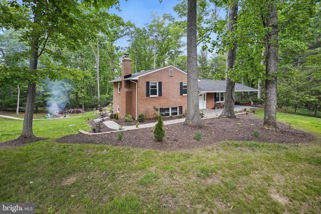 6404 Yates Ford Rd, Manassas, VA 20111 - split level home with brick siding, a chimney, a front lawn, a patio area, and view of wooded area