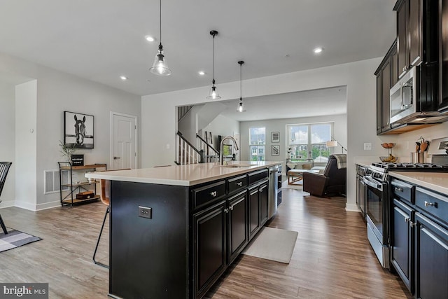 14540 Grace Kellen Ave, Brandywine, MD 20613 - kitchen with stainless steel appliances, a sink, open floor plan, light countertops, and light wood-style floors