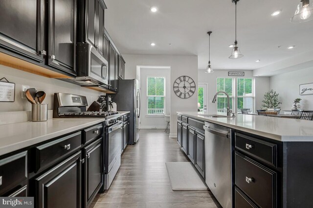14540 Grace Kellen Ave, Brandywine, MD 20613 - kitchen featuring stainless steel appliances, a sink, light countertops, light wood-style flooring, and dark cabinetry