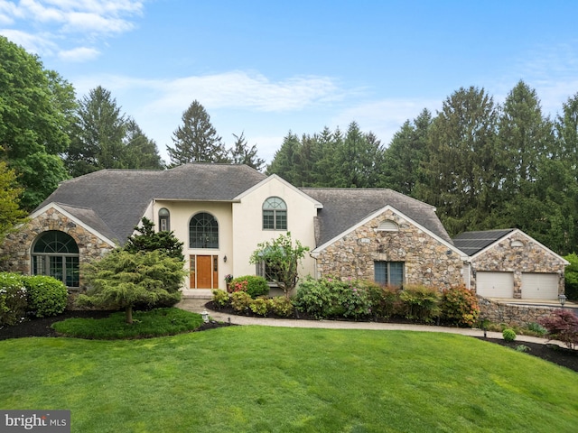 944 Old Public Rd, Hockessin, DE 19707 - view of front of home with stone siding, a front lawn, an attached garage, and stucco siding