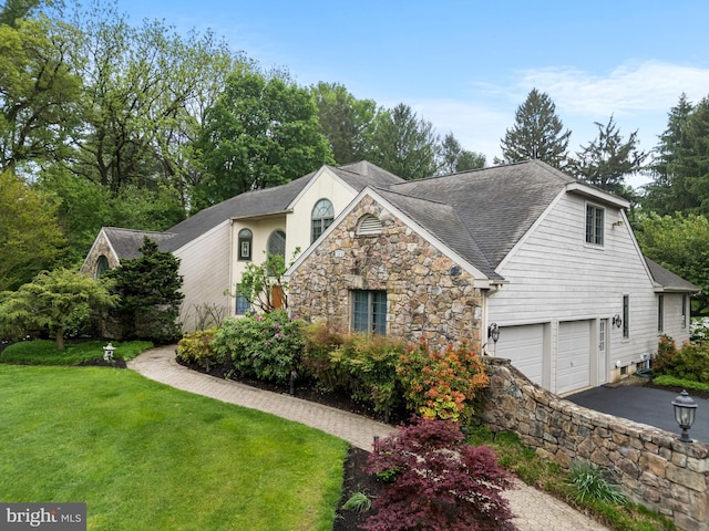 944 Old Public Rd, Hockessin, DE 19707 - view of home's exterior featuring a lawn, stone siding, asphalt driveway, and roof with shingles