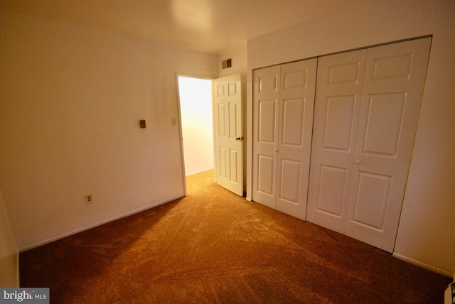 unfurnished bedroom featuring a closet, visible vents, baseboards, and carpet floors