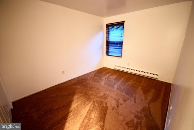 carpeted spare room featuring a baseboard heating unit