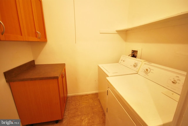 washroom with baseboards, washing machine and dryer, and cabinet space