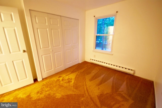 unfurnished bedroom featuring carpet, a closet, and baseboard heating