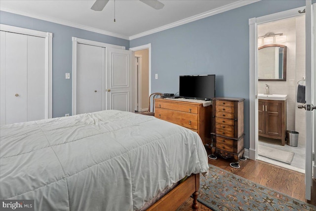 8513 Bound Brook Ln, Alexandria, VA 22309 - bedroom featuring wood finished floors, crown molding, a sink, two closets, and ensuite bathroom