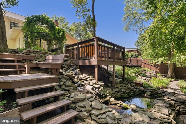 8513 Bound Brook Ln, Alexandria, VA 22309 - wooden terrace featuring stairway, fence, and a small pond
