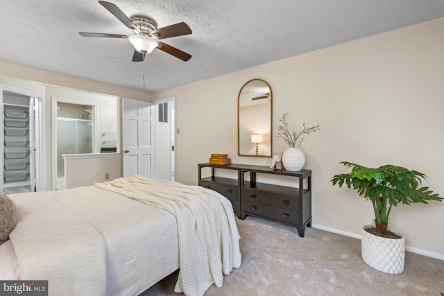 carpeted bedroom featuring baseboards, a textured ceiling, connected bathroom, and a ceiling fan