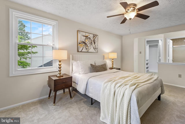 bedroom featuring carpet floors, a textured ceiling, baseboards, and ceiling fan