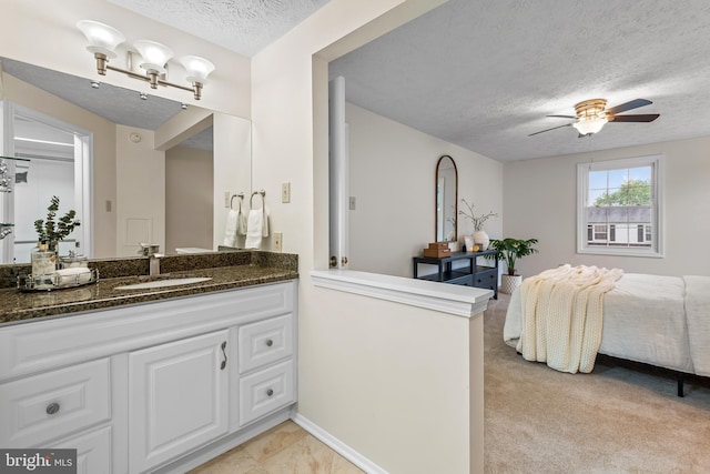 bathroom with a textured ceiling, ceiling fan, and vanity