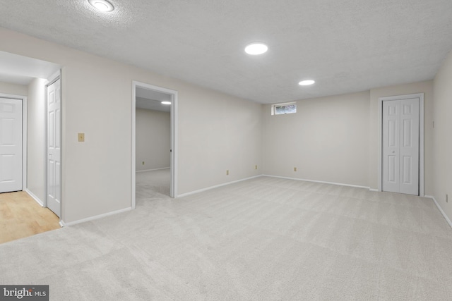 finished basement featuring carpet, baseboards, a textured ceiling, and recessed lighting