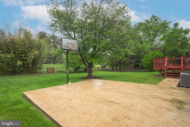 view of basketball court featuring basketball court and view of wooded area