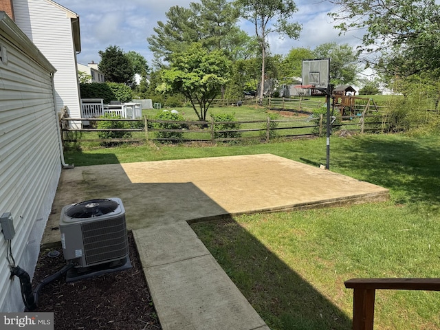 view of yard with central AC and a patio