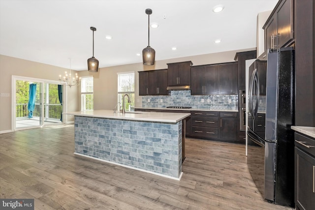 5609 Zoe Ln, Frederick, MD 21704 - kitchen with freestanding refrigerator, stainless steel gas stovetop, an inviting chandelier, a sink, and light countertops