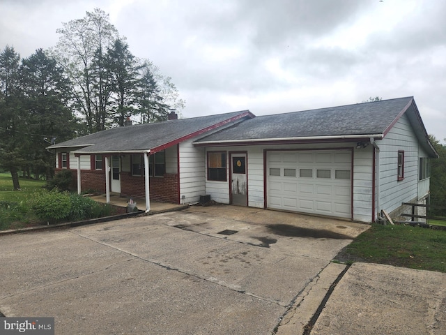 2153 Turnpike Rd, Elizabethtown, PA 17022 - ranch-style home with an attached garage, concrete driveway, a porch, roof with shingles, and brick siding