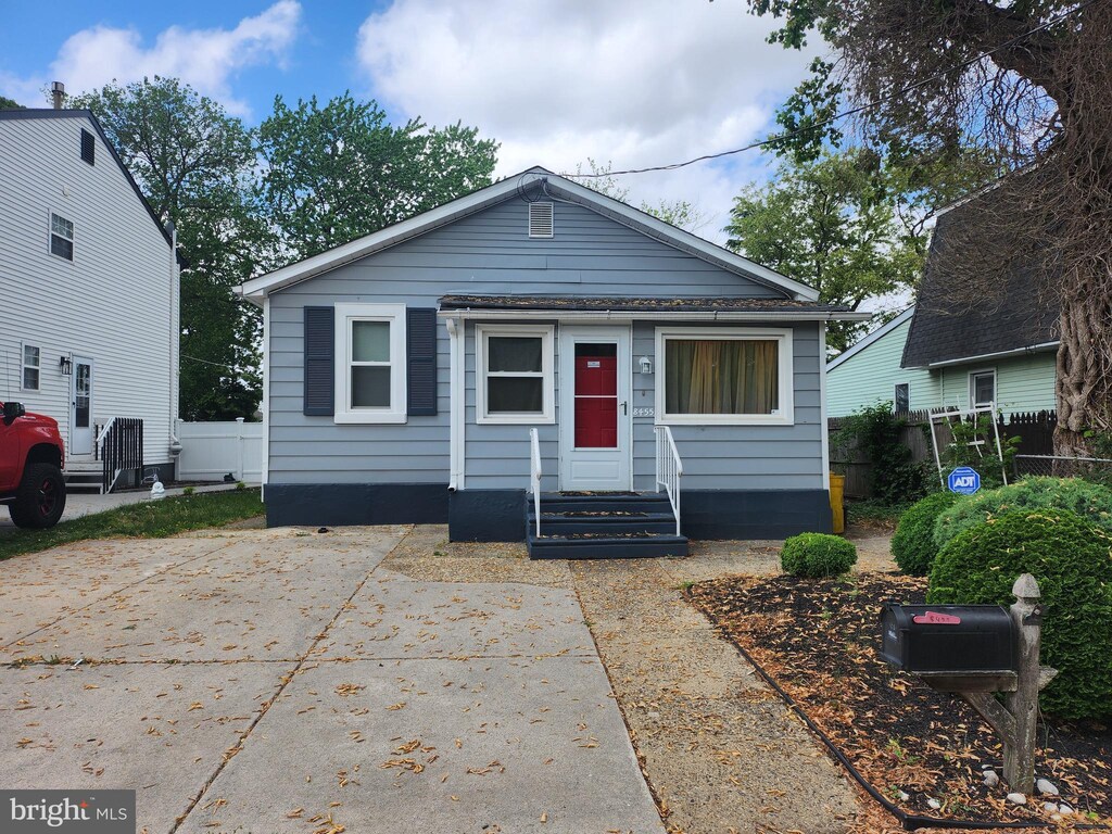 bungalow featuring entry steps and fence