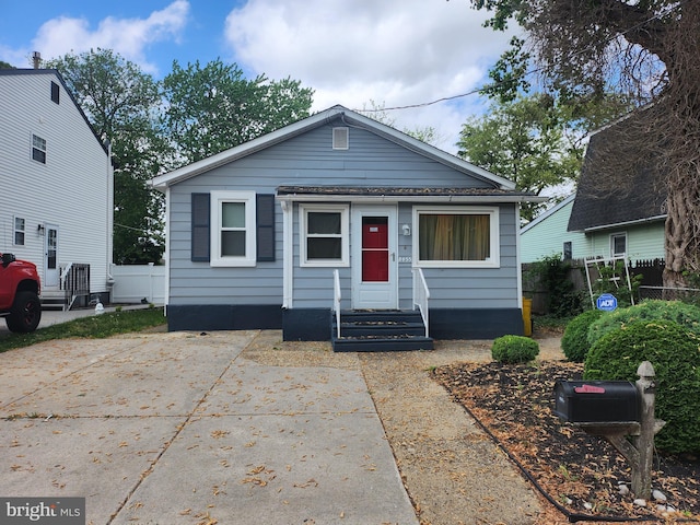 bungalow featuring entry steps and fence