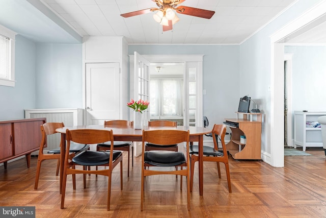 dining space featuring a ceiling fan, healthy amount of natural light, and crown molding