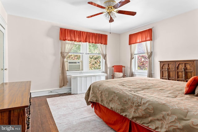 bedroom featuring radiator, wood-type flooring, baseboards, cooling unit, and a ceiling fan