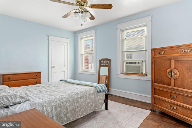 bedroom with cooling unit, wood finished floors, baseboards, and a ceiling fan