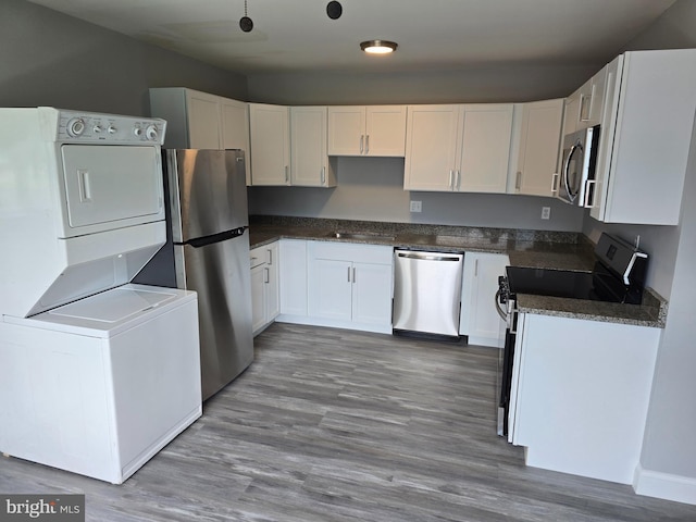 1079 Notley Ct, Pasadena, MD 21122 - kitchen featuring stainless steel appliances, stacked washer / drying machine, white cabinets, and wood finished floors
