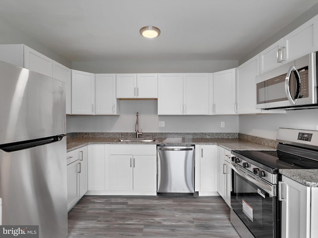 1079 Notley Ct, Pasadena, MD 21122 - kitchen with stainless steel appliances, a sink, white cabinetry, wood finished floors, and stone counters