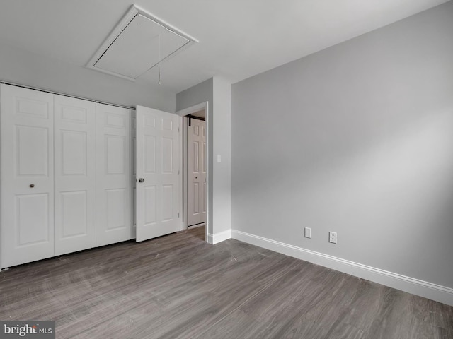 1079 Notley Ct, Pasadena, MD 21122 - unfurnished bedroom featuring attic access, wood finished floors, baseboards, and a closet