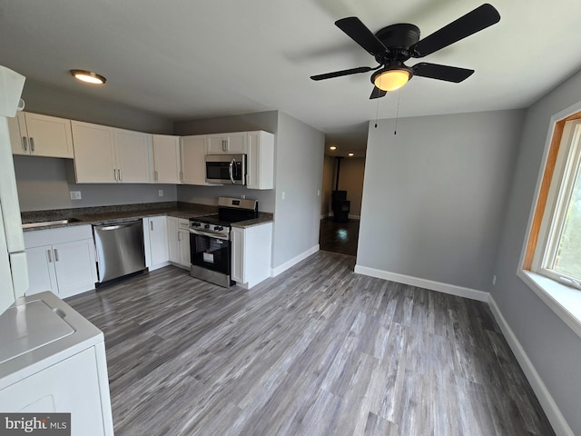 1079 Notley Ct, Pasadena, MD 21122 - kitchen with stainless steel appliances, baseboards, white cabinets, wood finished floors, and dark countertops
