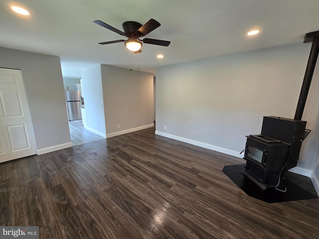 1079 Notley Ct, Pasadena, MD 21122 - unfurnished living room with a wood stove, ceiling fan, dark wood-style flooring, baseboards, and recessed lighting