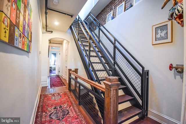 1830 Columbia Rd NW, Washington, DC 20009 - staircase featuring arched walkways, baseboards, and wood finished floors