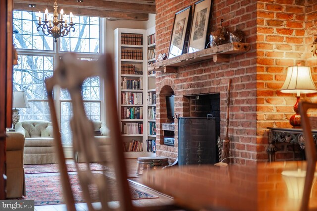 living area featuring a chandelier and a wood stove