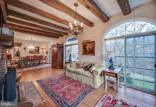 living room featuring a chandelier, beamed ceiling, and hardwood / wood-style floors