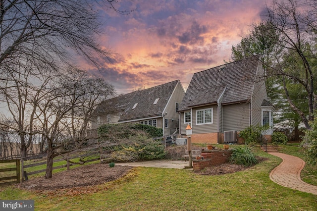 rear view of property featuring brick siding, central AC, and a patio area