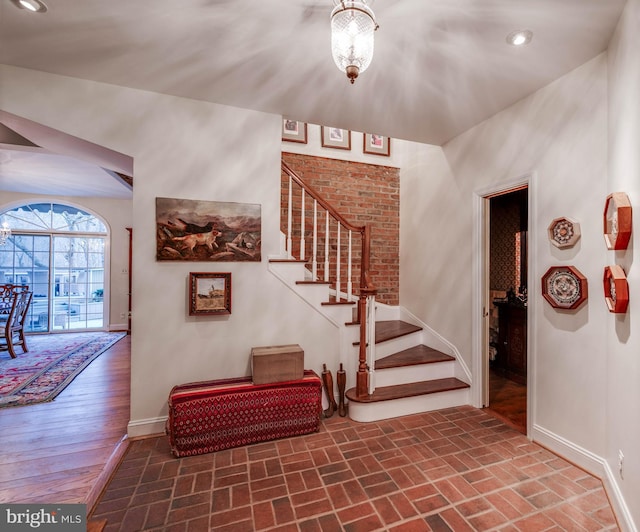 staircase with baseboards, recessed lighting, and brick patterned flooring