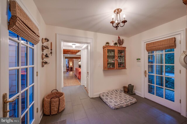 entryway featuring wood finished floors, a chandelier, and baseboards