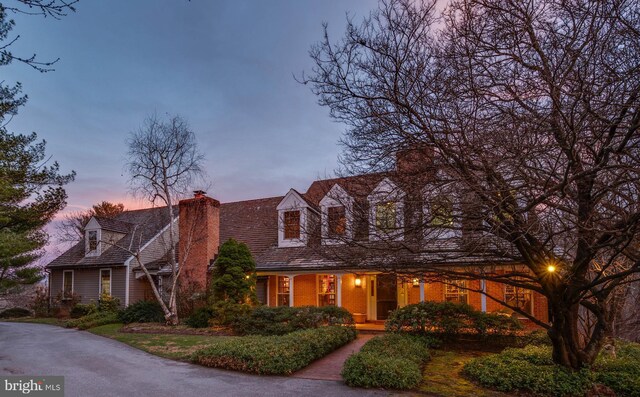 new england style home featuring a chimney